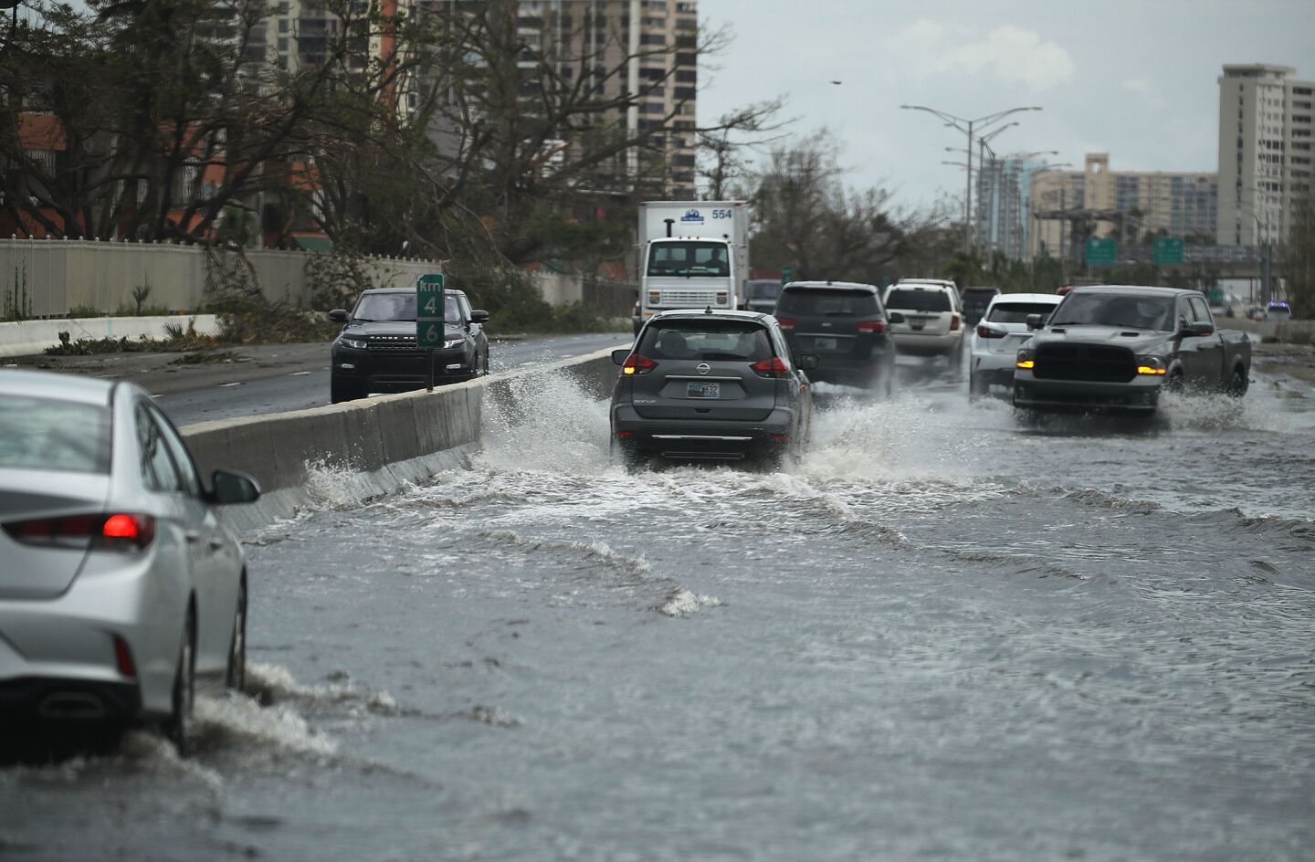 Vehicles drive along a flooded road after Hurricane Maria passed through the area in San Juan, Puerto Rico.