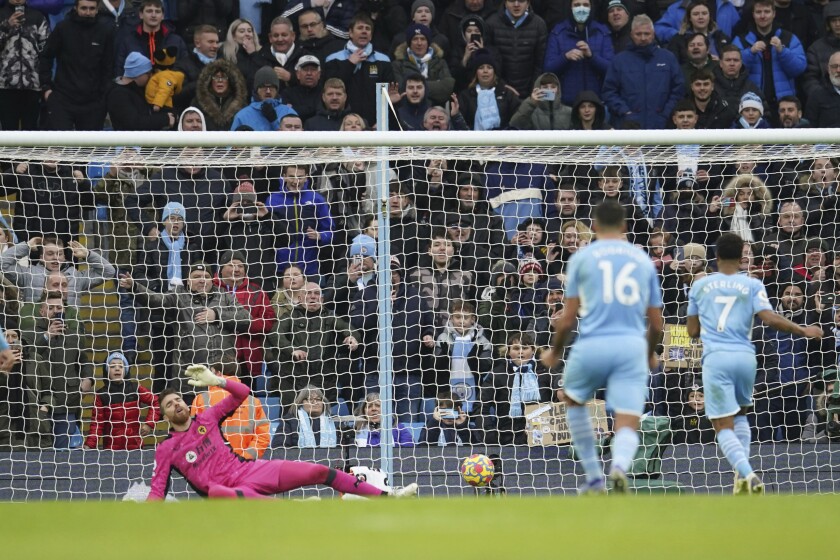 Manchester City's Raheem Sterling, right, scores his side's first goal on a penalty kick during the English Premier League soccer match between Manchester City and Wolverhampton Wanderers, at the Etihad stadium in Manchester, England, Saturday, Dec.11, 2021. (AP Photo/Dave Thompson)