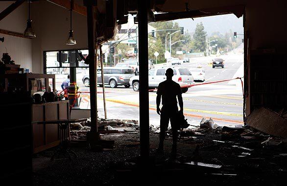 Workman Bill Andrew looks north out the front of the Flintridge Bookstore and Coffeehouse as vehicles descend Angeles Crest Highway toward La Cañada Flintridge's Foothill Boulevard. A big rig descending Angeles Crest barreled through the busy intersection on Wednesday, struck several vehicles and smashed into the bookstore/coffeehouse, killing two motorists and injuring 12 people, three of them critically.