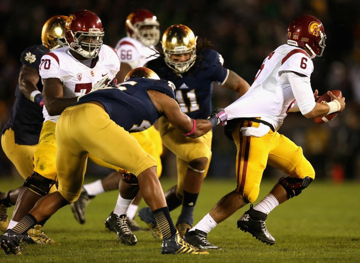 USC quarterback Cody Kessler tries to get away from Notre Dame's Romeo Okwara during the Trojans' 14-10 loss to the Fighting Irish in October 2013.