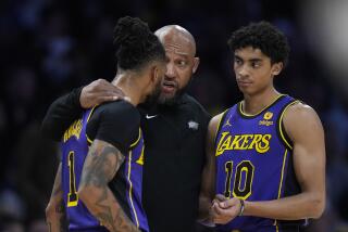 Los Angeles Lakers head coach Darvin Ham, center, talks with guards D'Angelo Russell (1) and Max Christie (10) during the first half of an NBA basketball game against the Milwaukee Bucks, Friday, March 8, 2024, in Los Angeles. (AP Photo/Jae C. Hong)