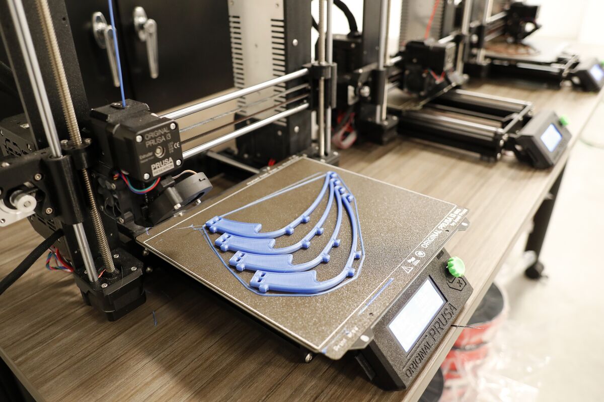 Face shield frames are produced with a 3-D printer at the UCI Beall Applied Innovation Cove in Irvine on Tuesday.