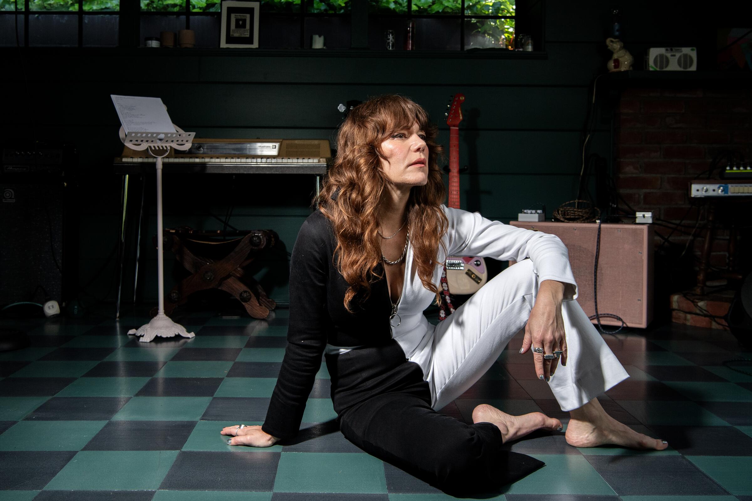 Jenny Lewis sits on the floor of a music room