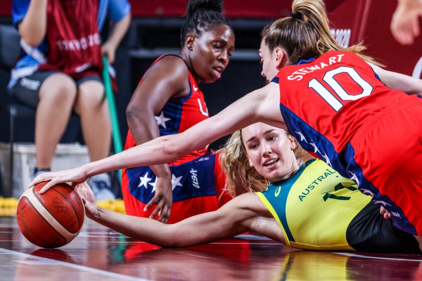 Tokyo, Japan,Wednesday, August 4, 2021 - Team United States forward Breanna Stewart (10) dives over Team Australia power forward Alanna Smith (11) for a loose ball during second half action at a Women's Basketball Quarterfinal at Saitama Super Arena. (Robert Gauthier/Los Angeles Times)