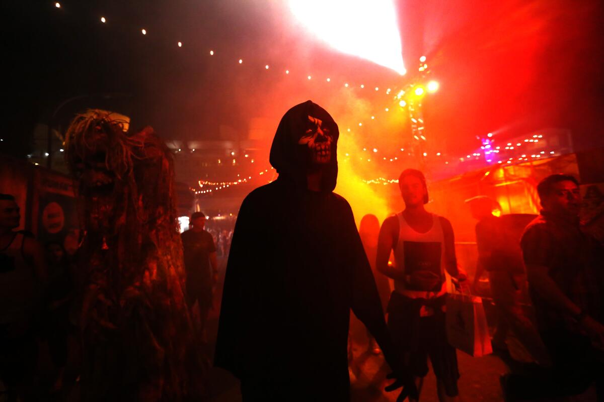 Creatures and ghouls mix in with visitors to "Dark Harbor" at the Queen Mary in Long Beach in October 2015.