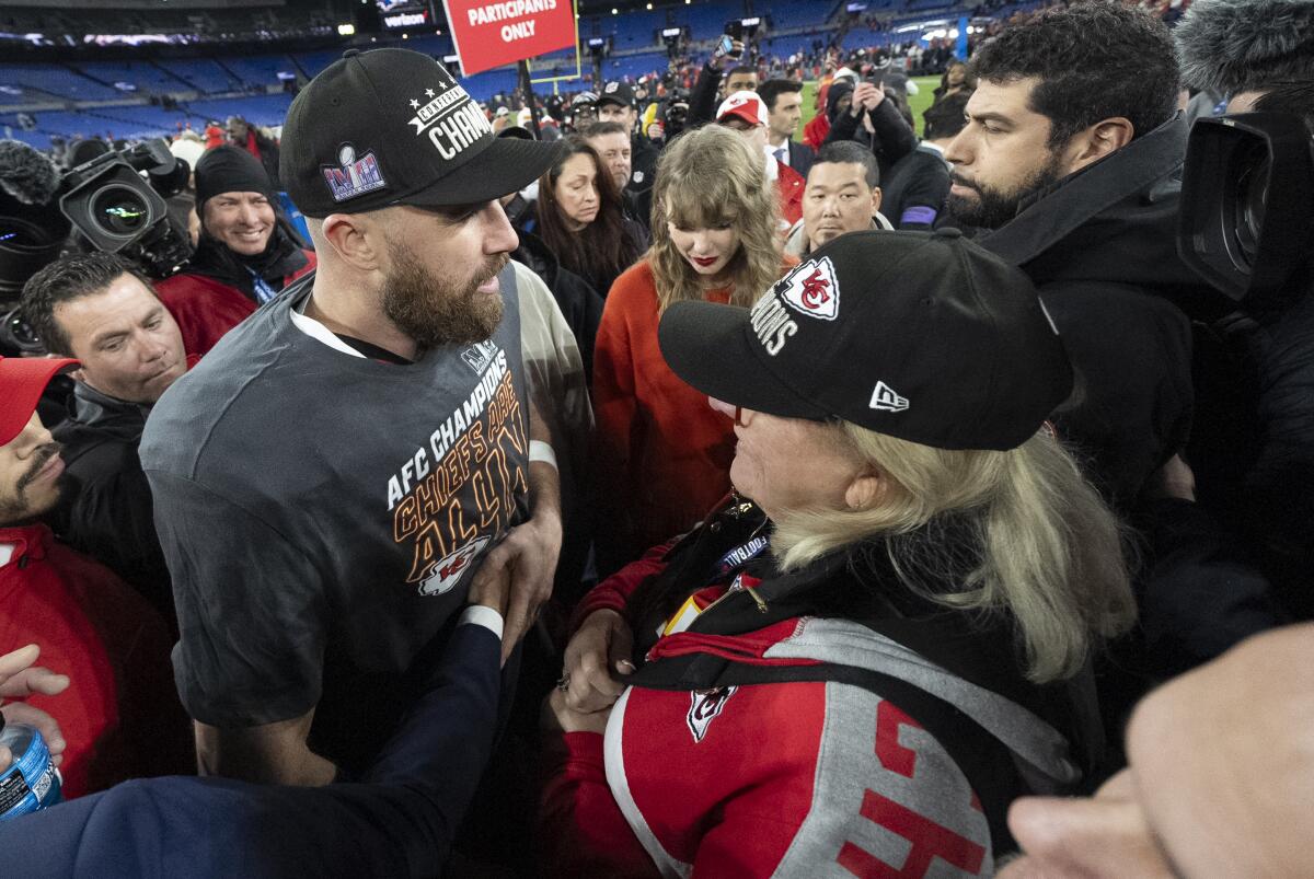 Kansas City Chiefs tight end Travis Kelce , left, talks to his mom Donna Kelce and Taylor Swift.