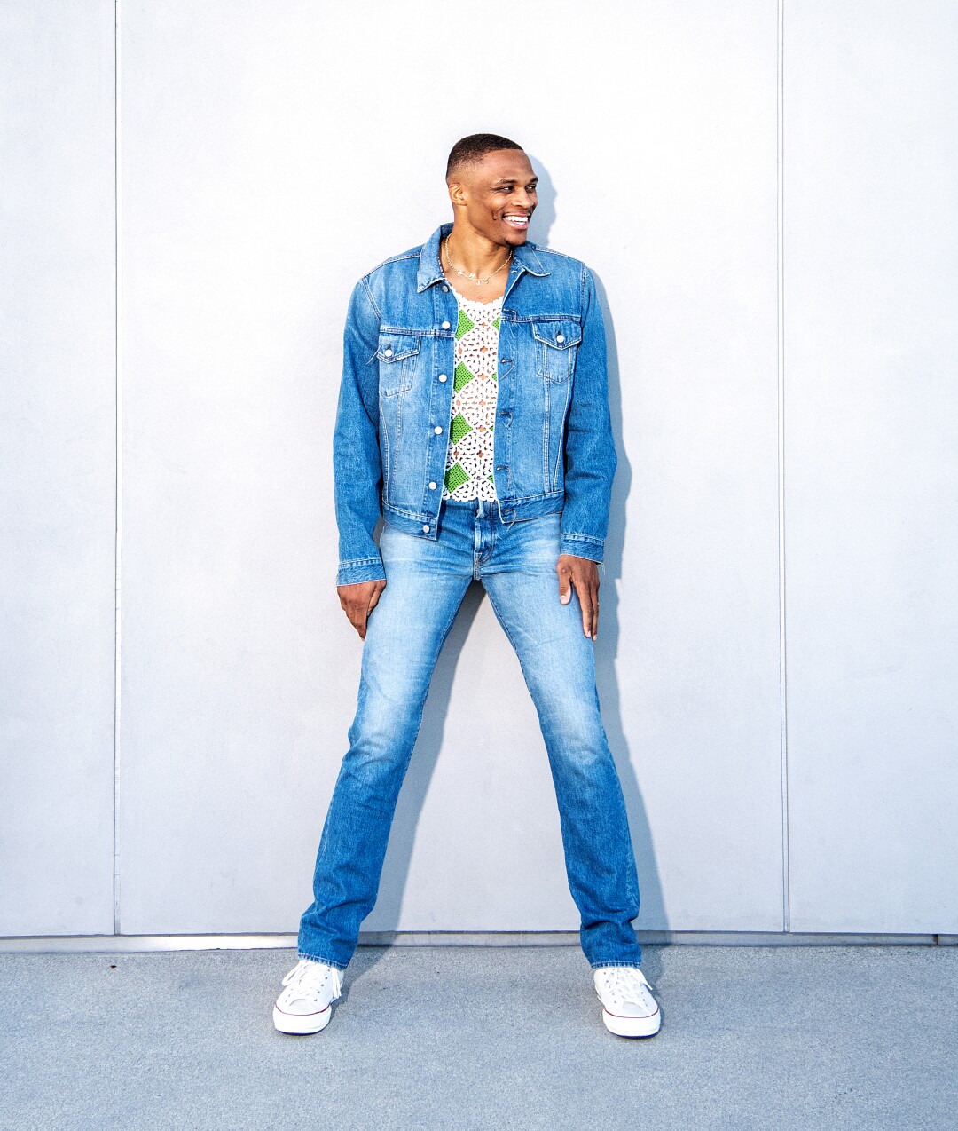 Russell Westbrook stands in jeans and a jean jacket