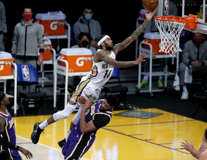 New Orleans Pelicans forward Brandon Ingram is called for charging as he tries to score over Lakers forward Anthony Davis.