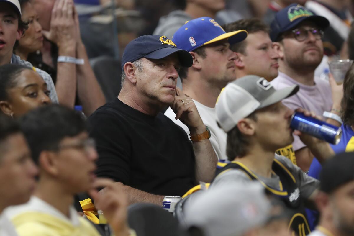 Athletics owner John Fisher, center, watches Game 2 of the 2022 NBA Finals in San Francisco.