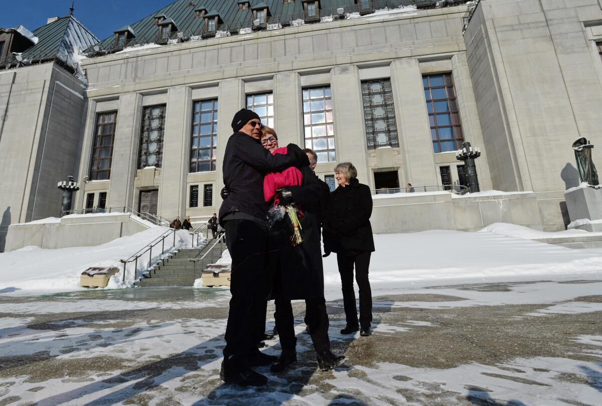 Lee Carter and her husband, Hollis Johnson, embrace outside the Supreme Court of Canada on Friday after a ruling that struck down the nation's absolute ban on doctor-assisted suicide. In 2010, Carter accompanied her 89-year-old mother to Switzerland, where she ended her life.