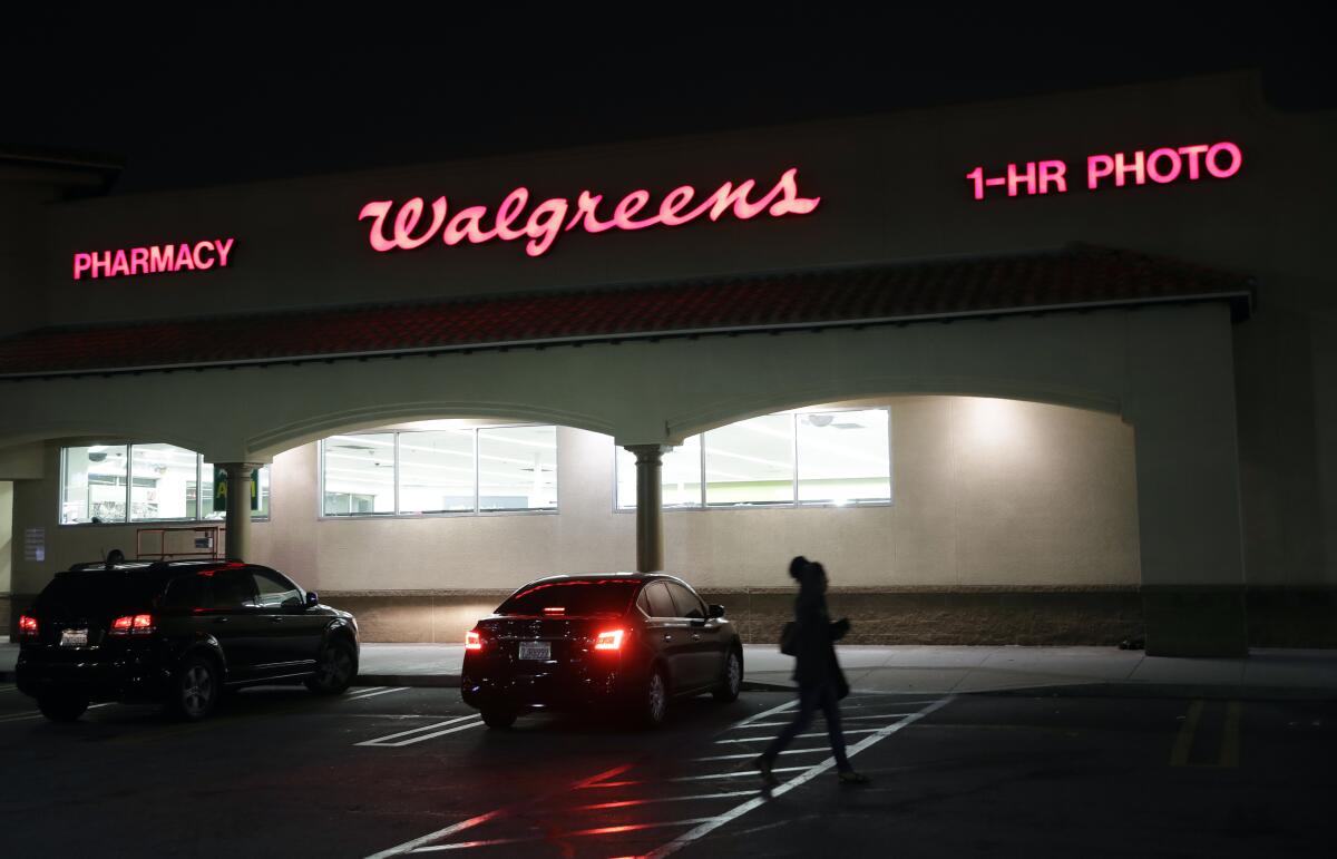 A person walks outside a Walgreens store