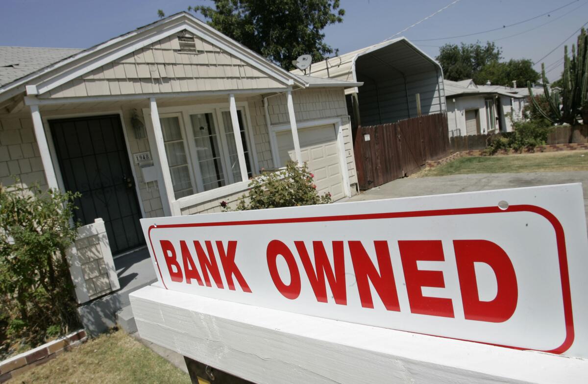 A "bank owned" sign stands in front of a house in Antioch, Calif.
