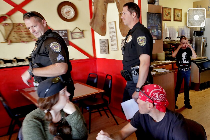 Police officers in Wickenburg, Ariz., leave the Horseshoe Cafe on May 1.