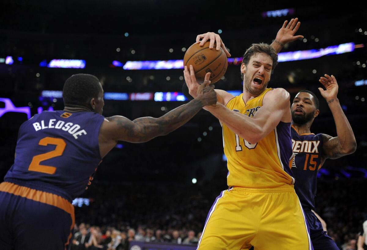 The Lakers' Pau Gasol, center, is pressured by Phoenix's Eric Bledsoe, left, and Marcus Morris during the Lakers' 114-108 loss to the Suns at Staples Center.