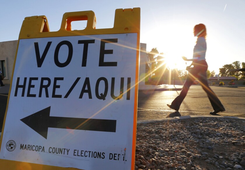 A voter arrives to cast her ballot at sunrise in Arizona's presidential primary election Tuesday.