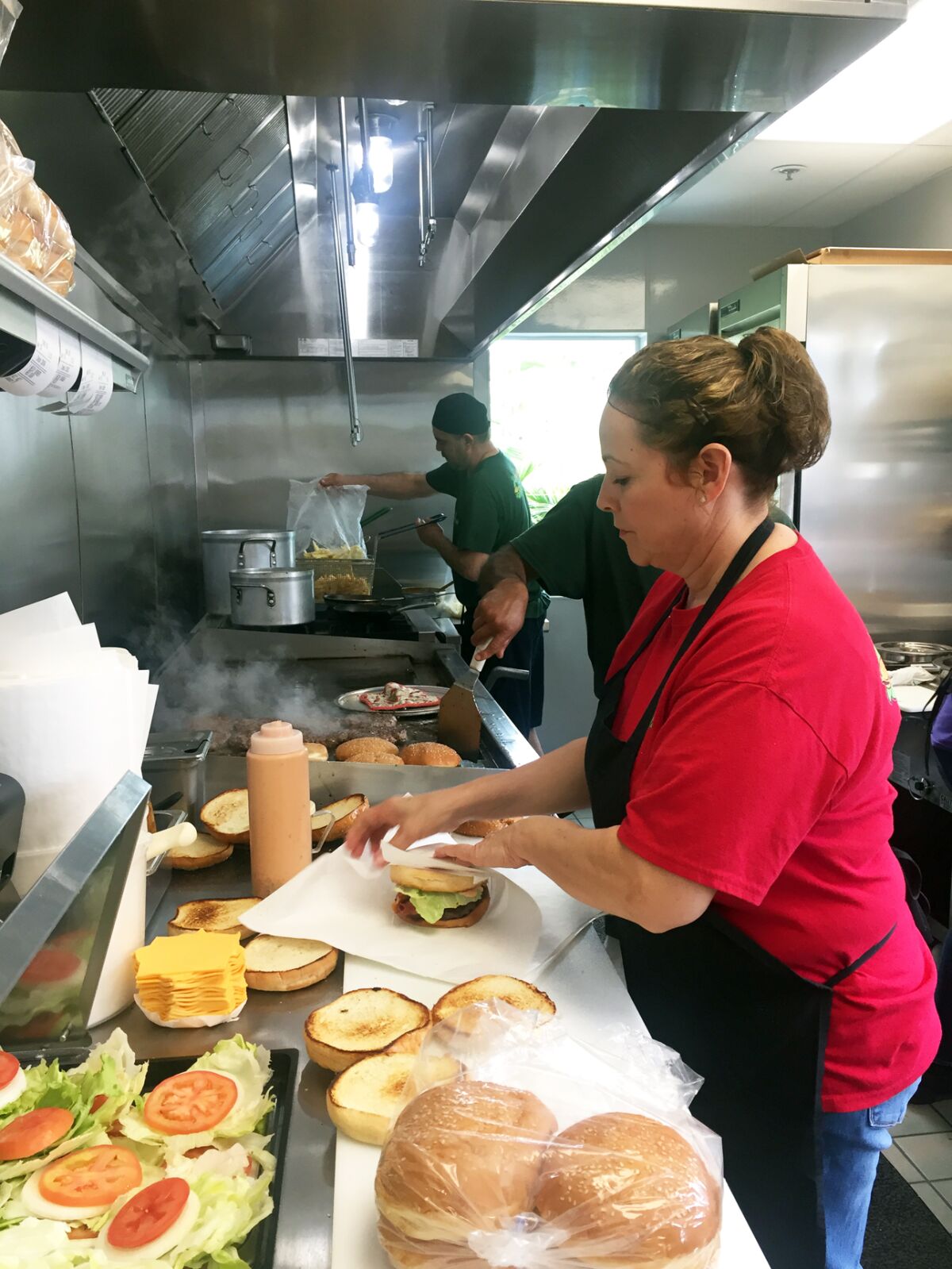 Nessy Burgers manager Rebeca Loera assembles Nessy Burgers at the Fallbrook restaurant, which moved into a permanent location in March after 30 years in an old camping trailer.
