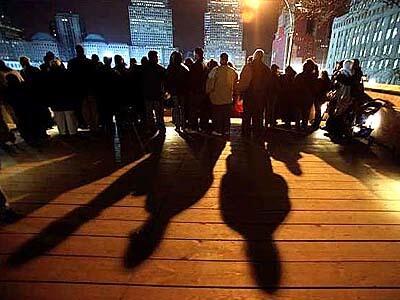 Nighttime visitors pay their respects from the viewing platform, entered at Broadway and Fulton Street.