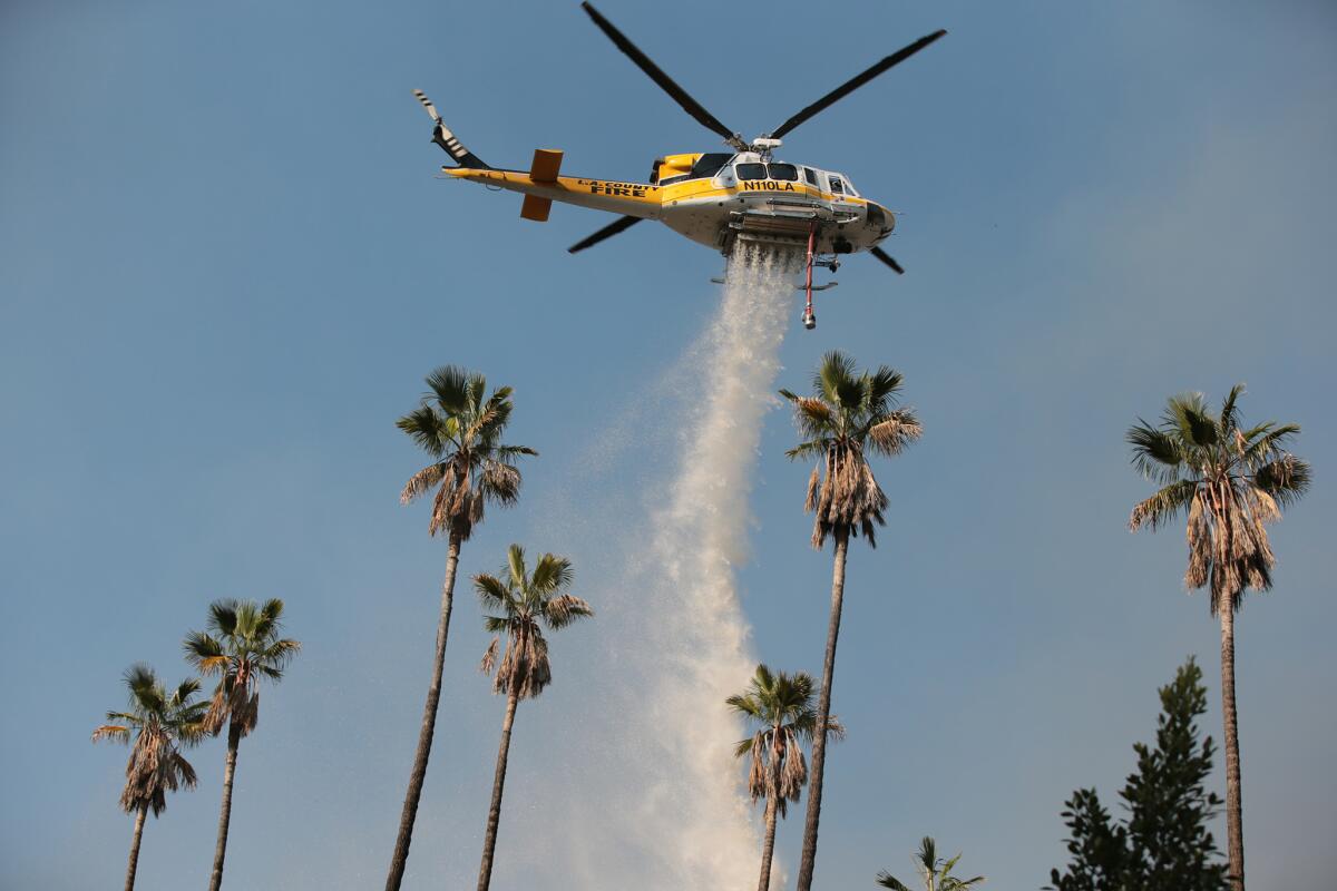 An L.A. County Fire Department helicopter drops water on the Colby fire above Glendora in January. The department and other agencies are bracing for fire weather this week.