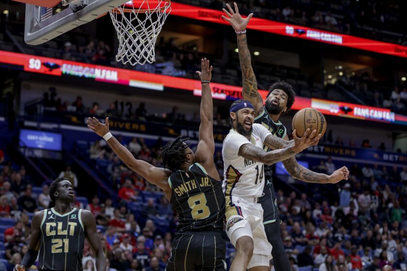 New Orleans Pelicans forward Brandon Ingram (14) scores and draws a foul on shot as Charlotte Hornets guard Dennis Smith Jr. (8) and center Nick Richards (4) defend in the first quarter of an NBA basketball game in New Orleans, Thursday, March 23, 2023. (AP Photo/Derick Hingle)