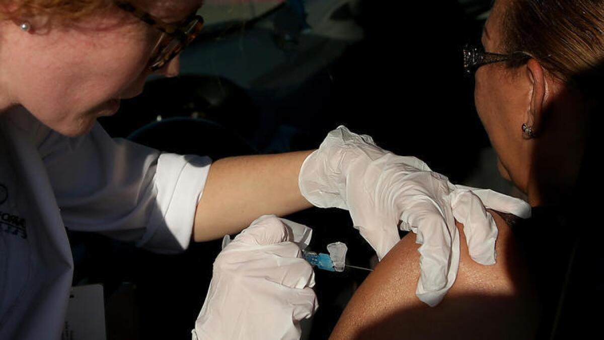 Vacunación contra la gripe desde el automóvil (drive-through), en una clínica de Doctors Medican Center en San Pablo, California, en noviembre de 2014.