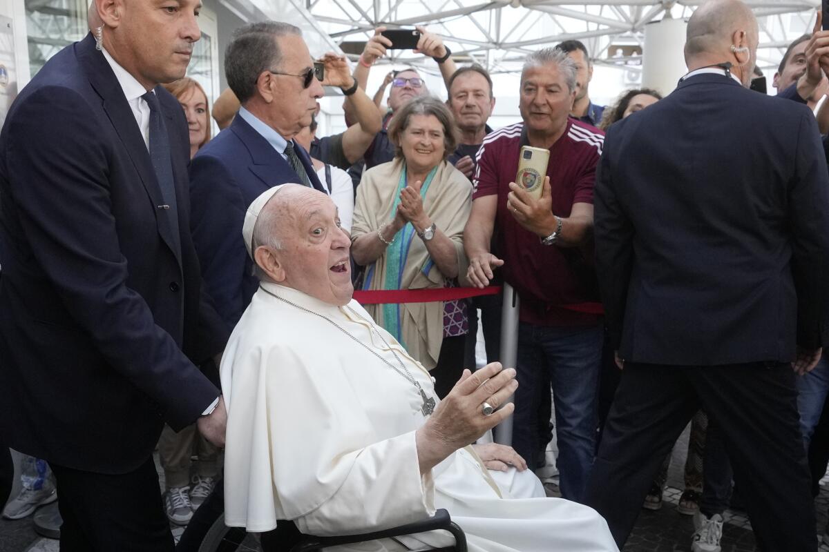 Pope Francis leaving a hospital amid well-wishers
