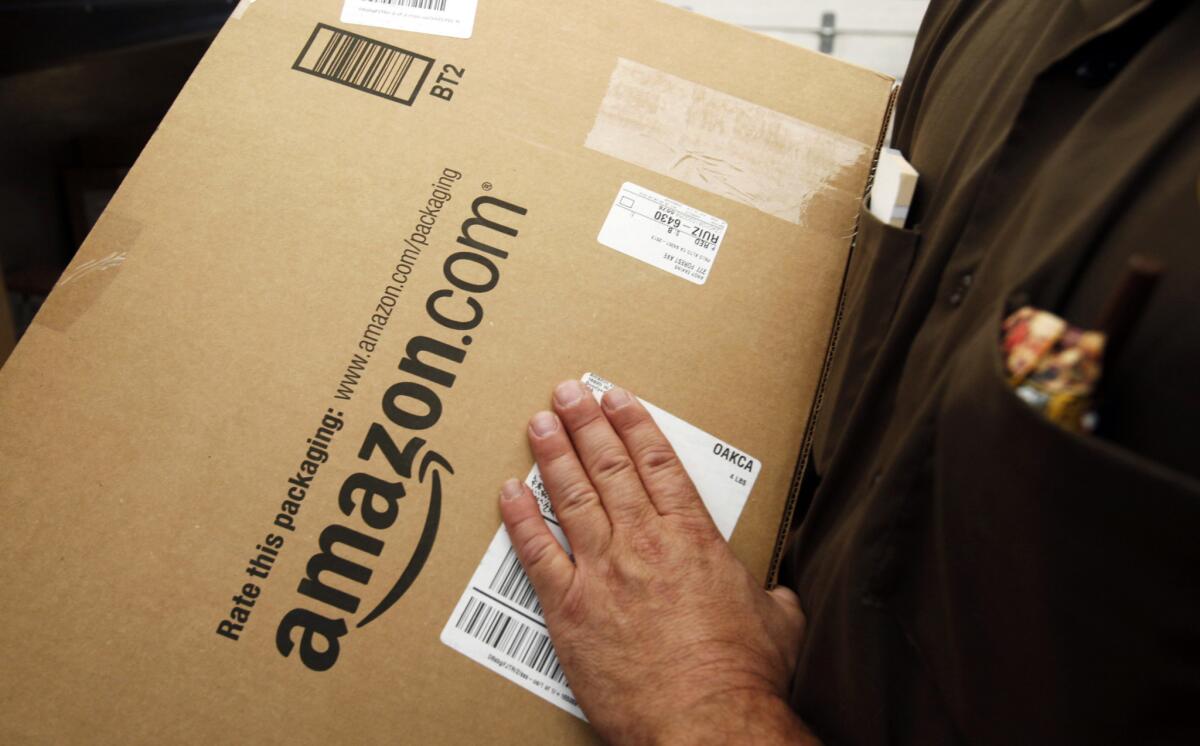 An Amazon.com package is prepared for shipment by a UPS driver in Palo Alto, Calif. A group of drivers for Amazon's new Prime Now delivery service filed suit Tuesday, alleging they have been improperly classified as independent contractors.