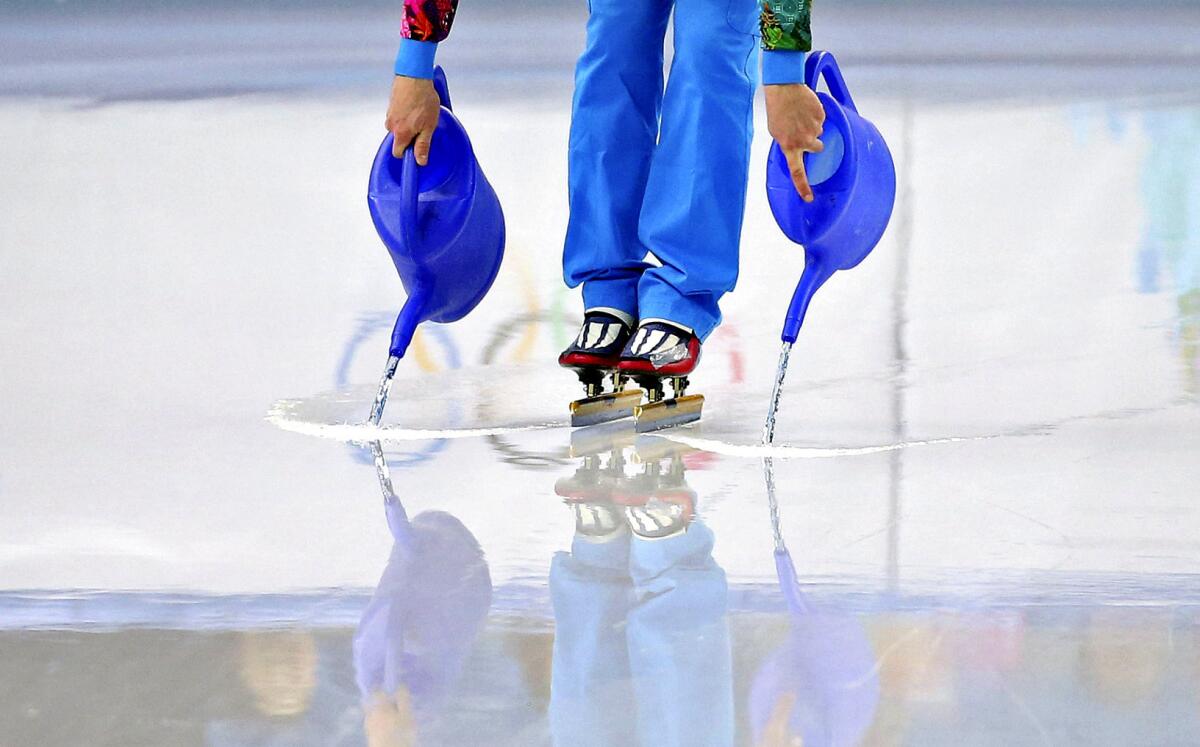 A worker pours jugs of water to repair the ice surface before the women's 3,000-meter short track relay semifinals at the Iceberg Skating Palace on Saturday during the 2014 Winter Olympics. The Iceberg hosts both short-track speedskating and figure skating -- two events which require different temperatures: The former is best at 20 degrees, the latter at 25 degrees. It can be difficult to make the adjustment with only a few hours between sessions.