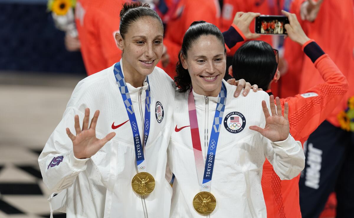 United States's Sue Bird, right, and Diana Taurasi pose with their gold medals during the medal ceremony for women's basketball at the 2020 Summer Olympics, Sunday, Aug. 8, 2021, in Saitama, Japan. (AP Photo/Charlie Neibergall)