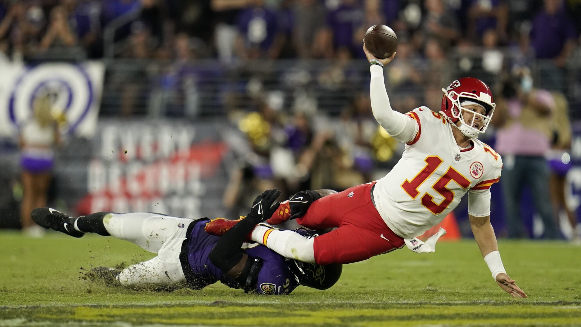 Kansas City Chiefs quarterback Patrick Mahomes throws as he is tackled by Baltimore Ravens linebacker Odafe Oweh.