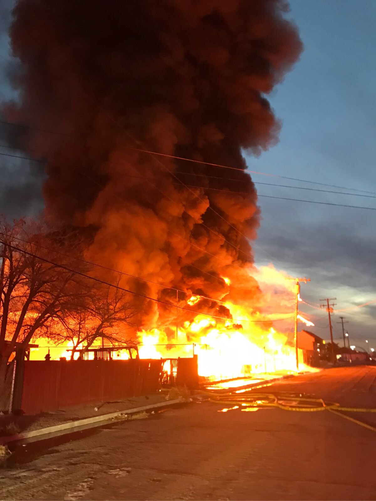 Flames and thick smoke rise from a commercial fire