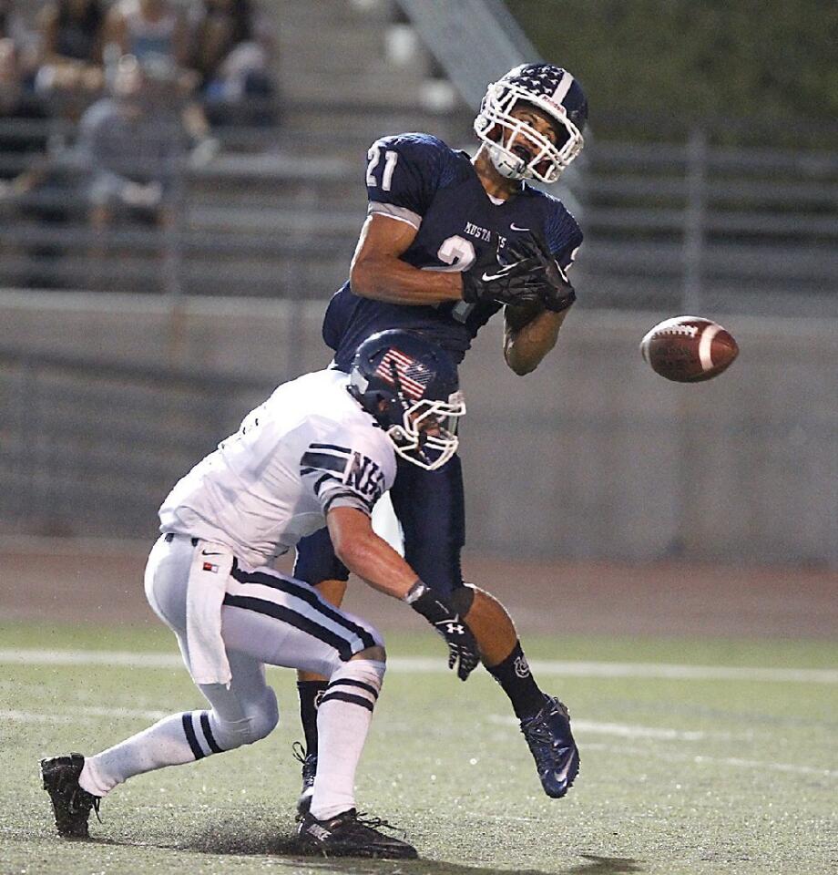 Newport Harbor High's Garrett Hall bumps into Trabuco Hills' Noah Thompson causing a fumble after a Newport punt in the first half on Friday.