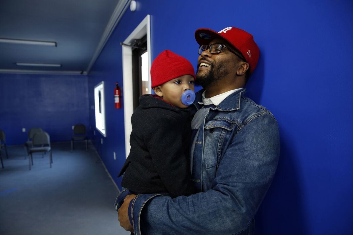Andrew Jackson II with son Tamir, 1, as he waits to get his hair trimmed in Jeanerette, La. Jackson attended President Obama's first inauguration in 2008 with his mother and father, Brenda and Andrew Jackson.
