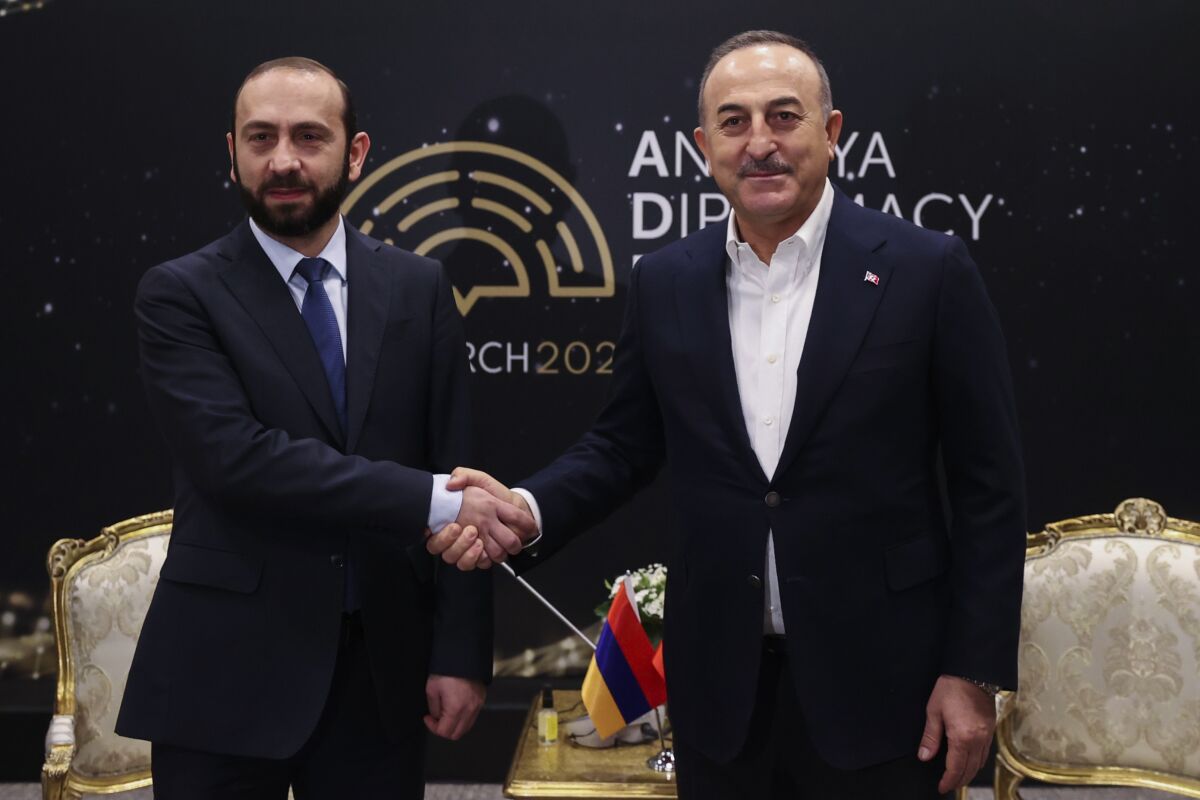 In this photo provided by Turkish Foreign Ministry, Armenia's Foreign Minister Ararat Mirzoyan, left, shakes hands with his Turkish counterpart Mevlut Cavusoglu during his meeting on the sidelines of the Antalya Diplomacy Forum in Antalya, Turkey, Saturday, March 12, 2022. Turkey and Armenia, which have no diplomatic ties, are engaged in talks aimed at ending decades of bitter relations between their two nations. (Cem Ozdel/Turkish Foreign Ministry via AP)