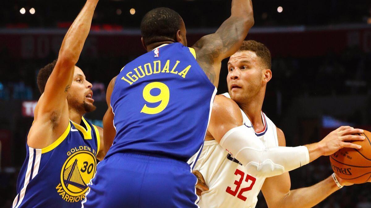 Golden State Warriors' Stephen Curry, left, and Andre Iguodala apply defensive pressure on Clippers forward Blake Griffin in the first quarter on Monday.