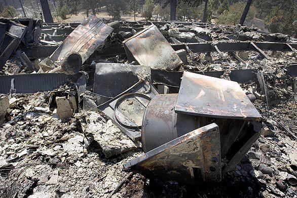 A burned dryer sits near the foundation of a home on East Whitlock Avenue near Mariposa, one of the areas hit hardest by the Telegraph fire. At least 25 homes overall have been destroyed by the fire near Yosemite, at least 10 of which were around Mariposa.