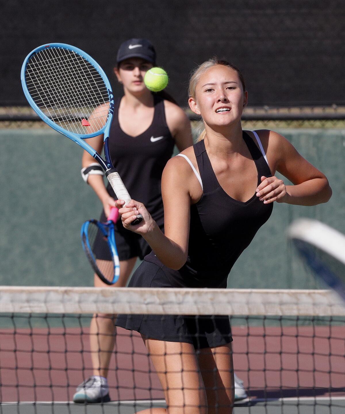 Glendale's Momo Guzman hits a return at the net in a semifinal doubles match against Arcadia with teammate Celine Khachiki in the Pacific League girls' tennis semifinals and finals at Burroughs High School on Wednesday, October 30, 2019. A couple of the contests were second-round contests, played today because of poor air quality on Monday.