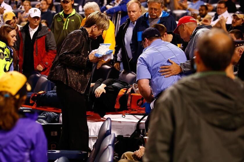 A woman is taken out by medical personnel on a stretcher after being struck by a foul ball in the back of the head in the second inning during a Pirates/Cubs game at PNC Park.