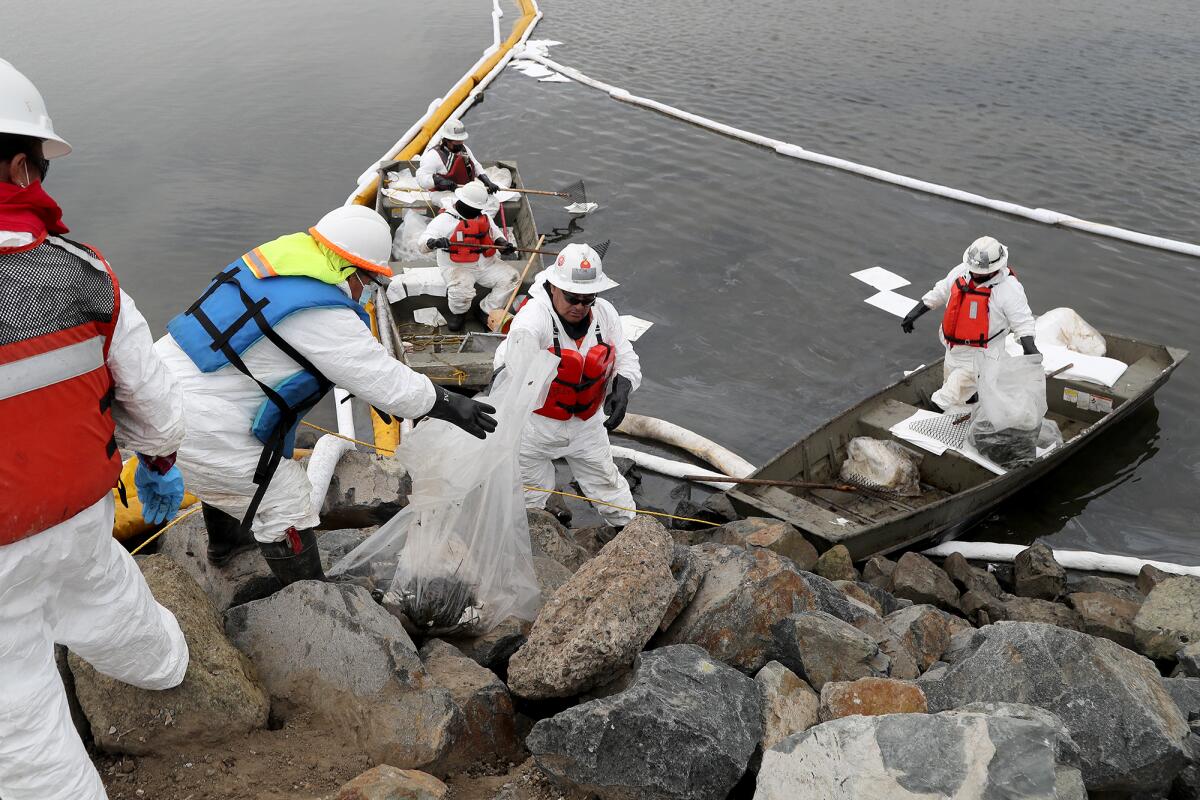 Contractors with Patriot Environmental Services continue with the oil spill cleanup on Wednesday in Huntington Beach.