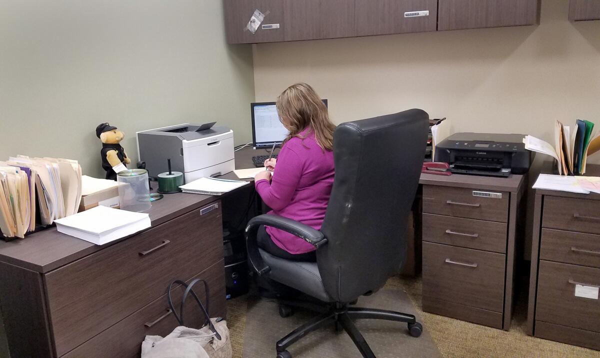 Regina Kirk, who is married to the Martin County sheriff, does payroll one evening. She has a full-time job elsewhere, but manages payroll and files financial reports for the sheriff's office free of charge in the evenings and on weekends.
