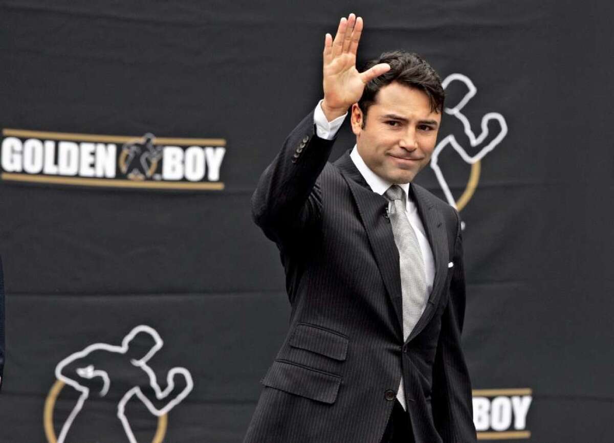 Oscar De La Hoya waves to a crowd before announcing his retirement from fighting on April 14, 2009.