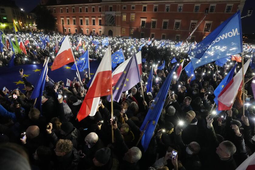 People hold up the flashlights of their mobile phones during a demonstration in support of Poland's EU membership in Warsaw, Poland, Sunday, Oct. 10, 2021. Poland's constitutional court ruled Thursday that Polish laws have supremacy over those of the European Union in areas where they clash, a decision likely to embolden the country's right-wing government and worsen its already troubled relationship with the EU. (AP Photo/Czarek Sokolowski)