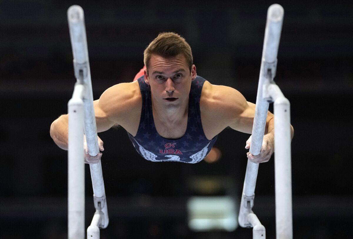 FILE - In this June 26, 2021, file photo, Sam Mikulak competes on the parallel bars during the men's U.S. Olympic Gymnastics Trials in St. Louis. On the eve of the Tokyo Games, it’s clear that just arriving at this point for some of the world’s greatest athletes was more of a mental-health challenge than it was a physical one. The COVID-19 postponement altered years of training plans, and the uncertain landscape amid the ongoing pandemic only added to lingering anxiety. (AP Photo/Jeff Roberson, File)