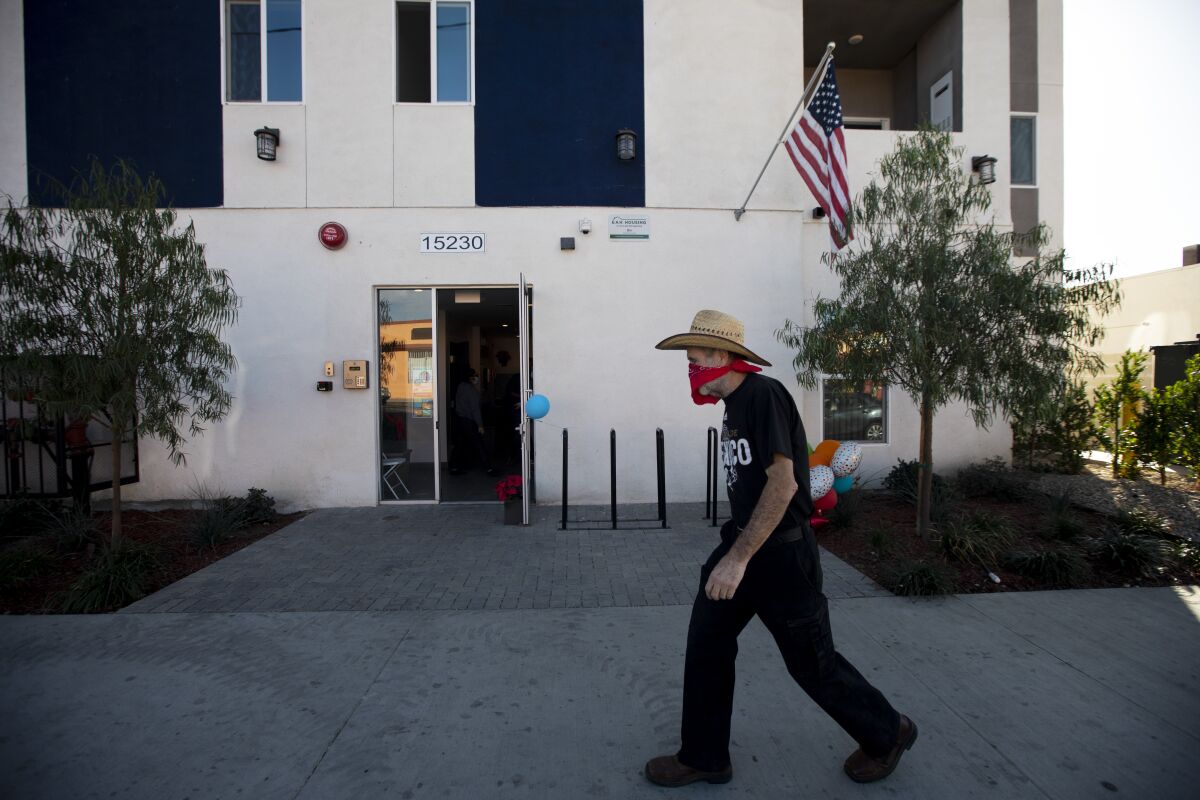 A man walks past the entrance of new permanent housing in North Hills.