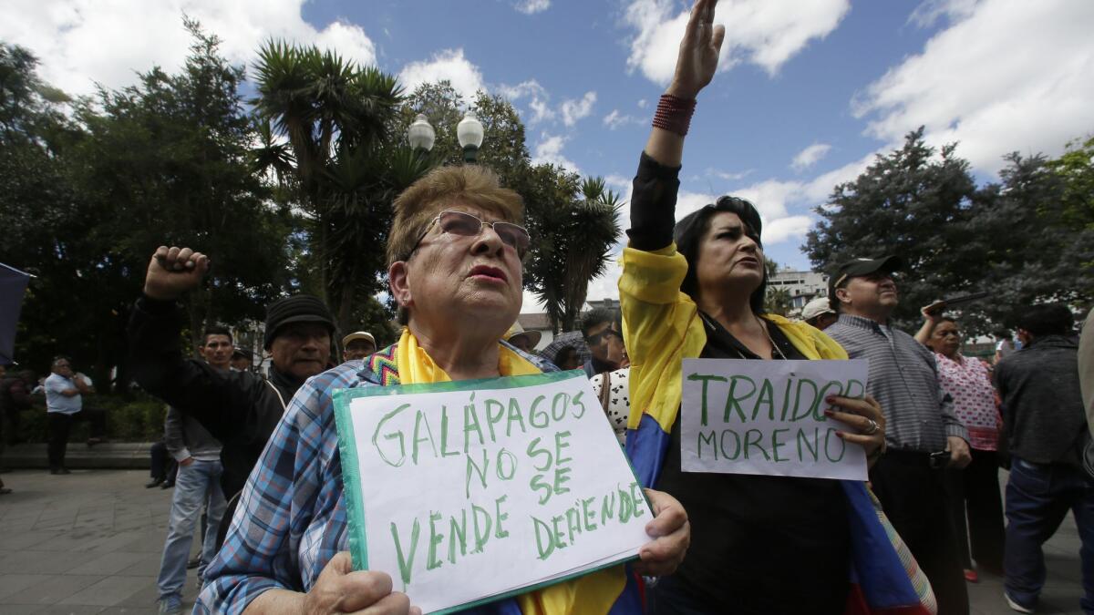 A woman in Quito, Ecuador, holds a sign that reads, "Galapagos is not to be sold, but to be defended," during a protest on June 17, 2019.