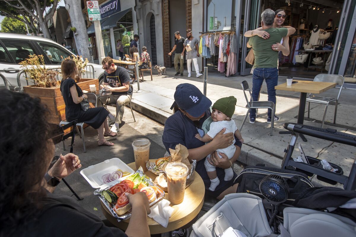A woman holds onto her infant son while having lunch at Groundwork on Larchmont Boulevard.