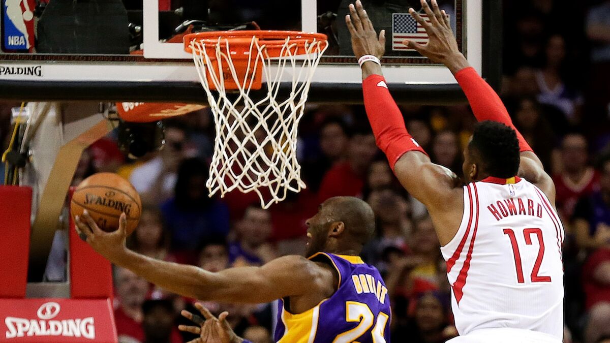 Lakers guard Kobe Bryant tries to score against Rockets center Dwight Howard on a drive down the lane Sunday.