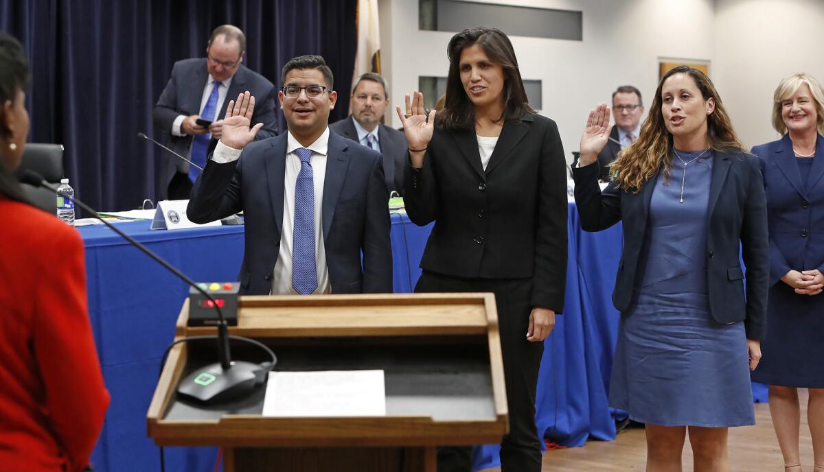 New Costa Mesa City Council members Manuel Chavez, Arlis Reynolds and Andrea Marr, from left, are sworn in Tuesday.