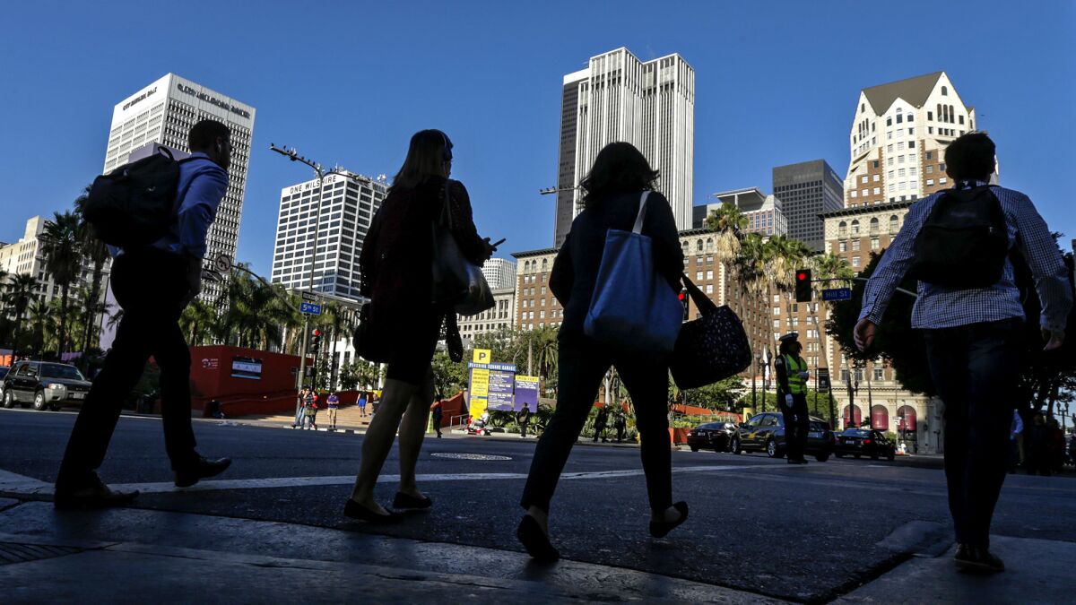 Pedestrians cross Hill Street across from Pershing Square in downtown L.A..