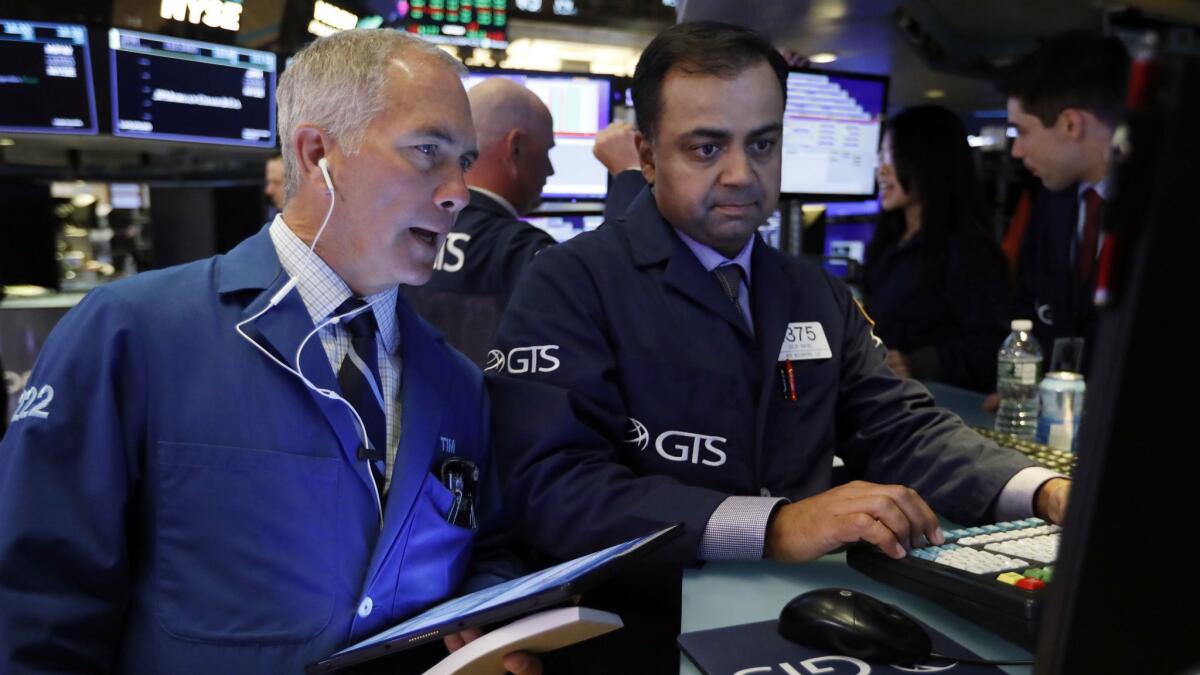 Trader Timothy Nick, left, and specialist Dilip Patel work on the floor of the New York Stock Exchange on Tuesday.