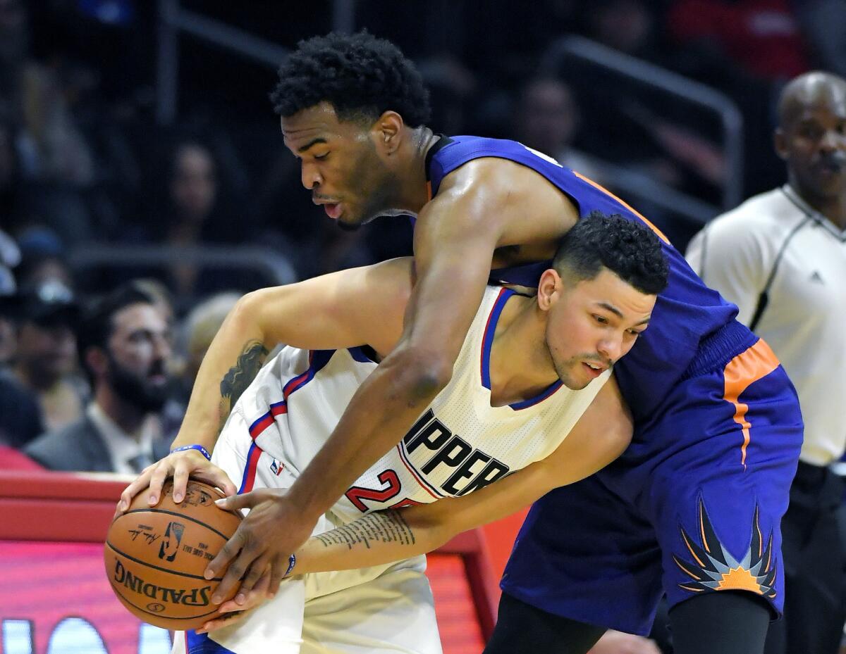 Suns forward T.J. Warren, right, reaches over Clippers guard Austin Rivers for the ball during the first half on Oct. 31.